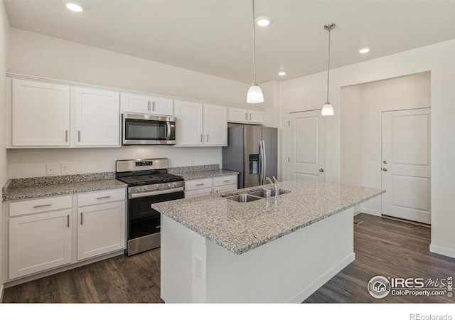 kitchen featuring pendant lighting, sink, white cabinets, stainless steel appliances, and light stone countertops