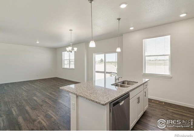 kitchen with sink, stainless steel dishwasher, an island with sink, light stone countertops, and white cabinets