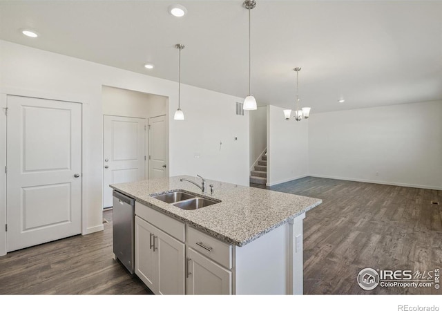 kitchen featuring decorative light fixtures, an island with sink, sink, white cabinets, and stainless steel dishwasher