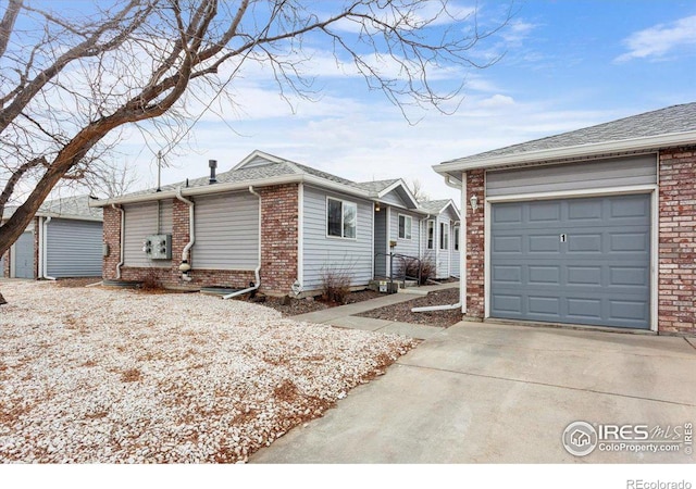 view of front of house with a garage, driveway, brick siding, and a shingled roof