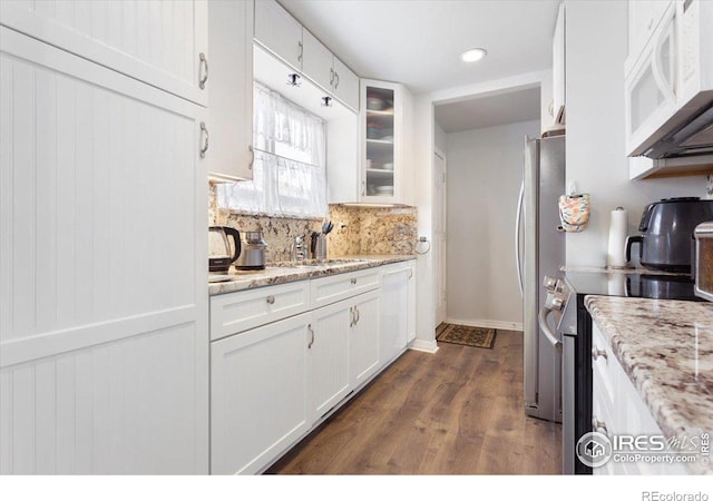 kitchen featuring tasteful backsplash, sink, white cabinets, stainless steel appliances, and light stone countertops