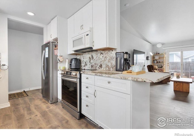 kitchen featuring stainless steel appliances, white cabinetry, backsplash, and dark hardwood / wood-style flooring