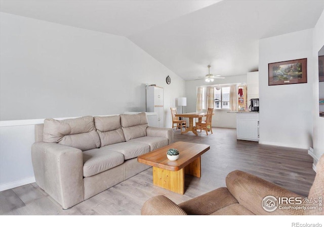 living room with ceiling fan, lofted ceiling, and light hardwood / wood-style flooring