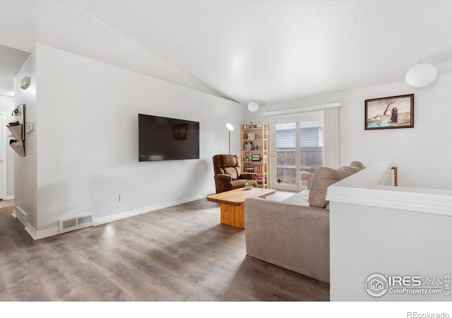 living room with hardwood / wood-style flooring and vaulted ceiling