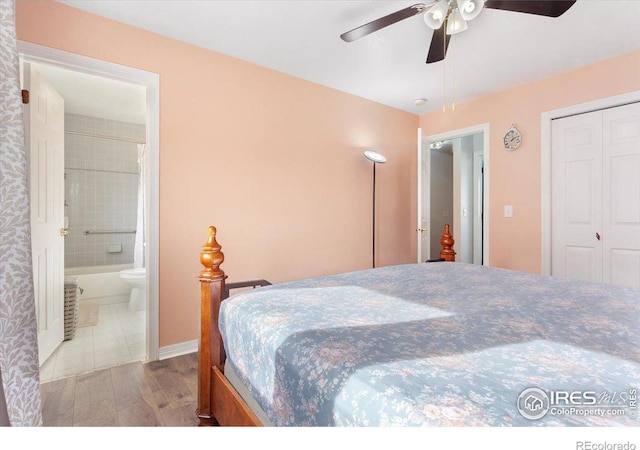 bedroom featuring ceiling fan, connected bathroom, light hardwood / wood-style floors, and a closet