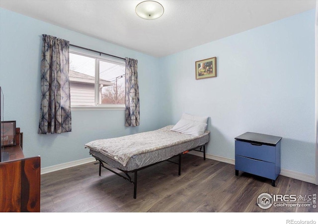 bedroom with dark hardwood / wood-style floors