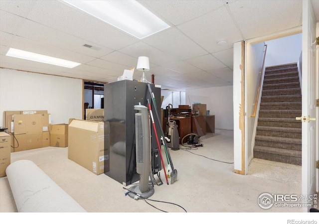 basement featuring a paneled ceiling and carpet