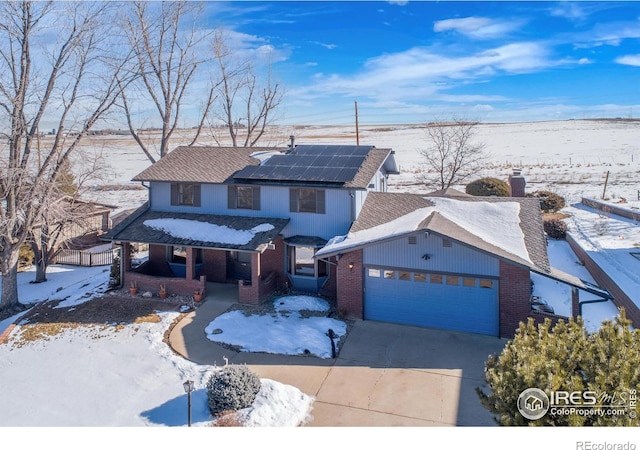 front of property with a garage and solar panels