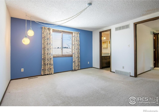 carpeted spare room featuring a textured ceiling