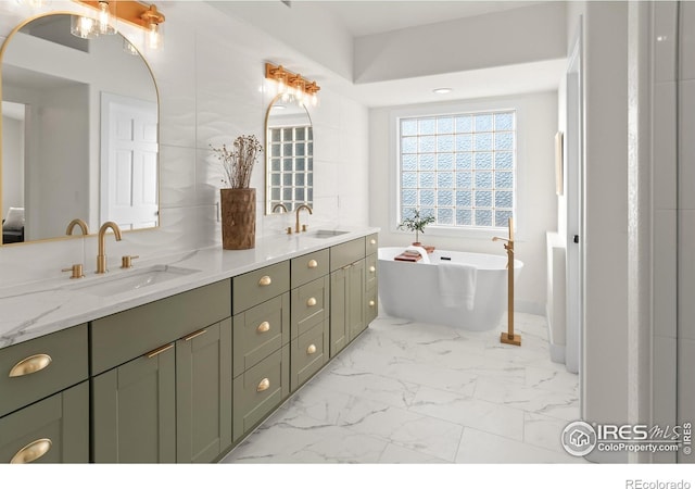 bathroom featuring a sink, a freestanding tub, marble finish floor, and double vanity