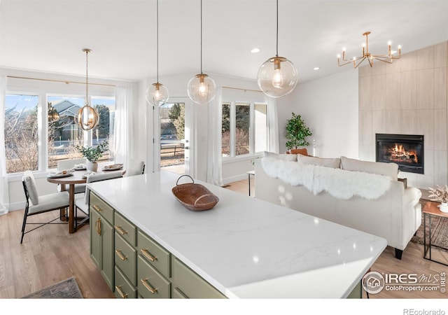 kitchen with light wood finished floors, recessed lighting, a fireplace, and green cabinets