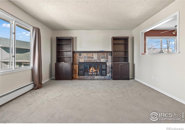 unfurnished living room with a fireplace, carpet flooring, ceiling fan, baseboard heating, and a textured ceiling