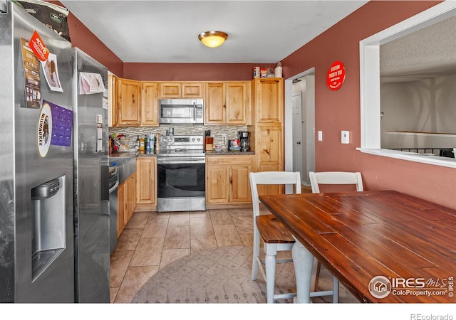 kitchen with tasteful backsplash, light brown cabinets, and appliances with stainless steel finishes