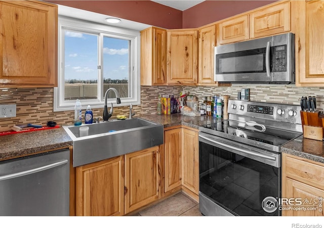 kitchen featuring sink, decorative backsplash, stainless steel appliances, and light tile patterned flooring