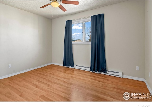 spare room with ceiling fan, hardwood / wood-style flooring, a baseboard radiator, and a textured ceiling