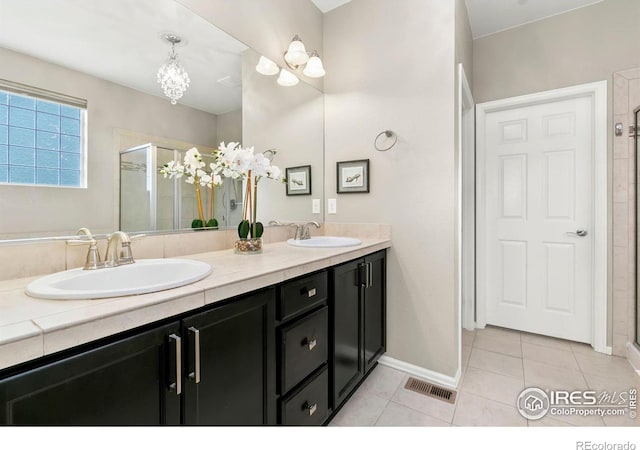 bathroom featuring tile patterned flooring, vanity, and a shower with door