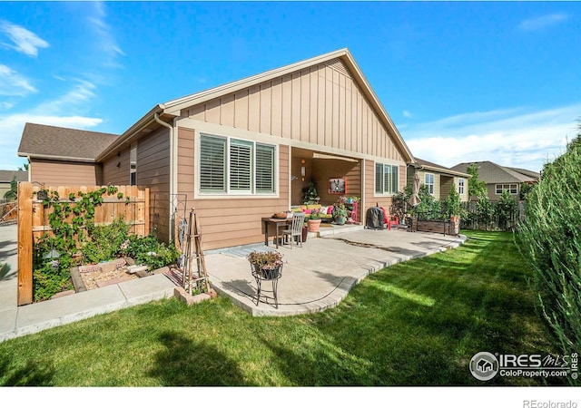 rear view of house with a yard and a patio area