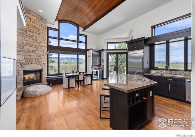 kitchen featuring a kitchen island with sink, sink, stainless steel appliances, and a breakfast bar