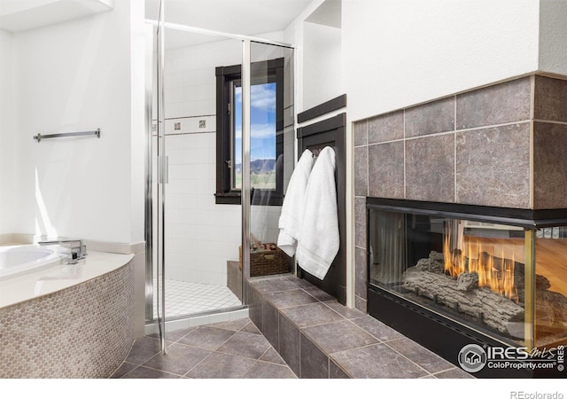 bathroom featuring a tiled fireplace, tile patterned flooring, and walk in shower