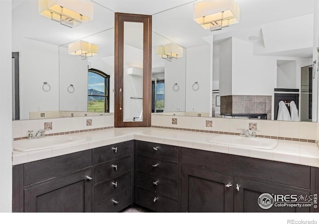 bathroom with vanity and tasteful backsplash