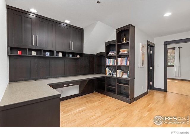 office space with built in desk and light hardwood / wood-style floors