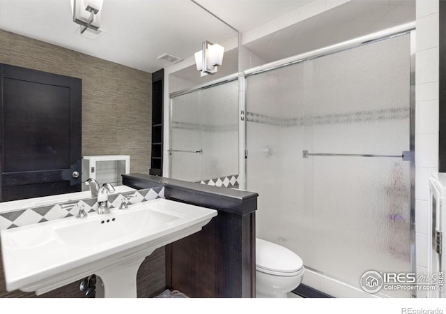 bathroom with sink, toilet, and walk in shower