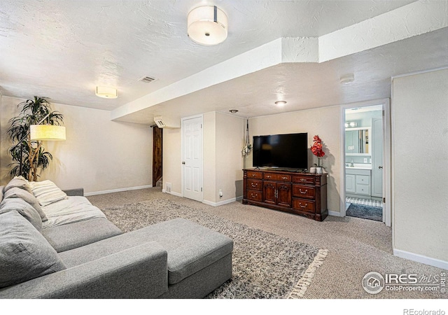 living area featuring a textured ceiling, carpet flooring, visible vents, and baseboards