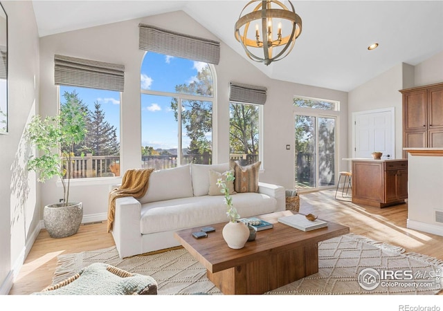 living room with plenty of natural light, a notable chandelier, and light hardwood / wood-style floors