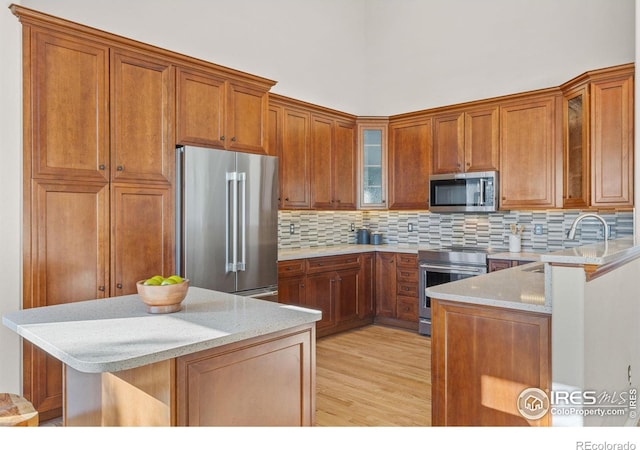 kitchen featuring light stone countertops, appliances with stainless steel finishes, sink, and a breakfast bar