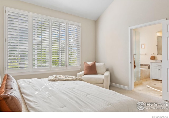 bedroom featuring lofted ceiling, connected bathroom, and light tile patterned flooring