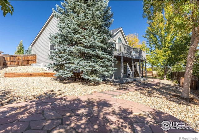 back of house with a deck and a patio