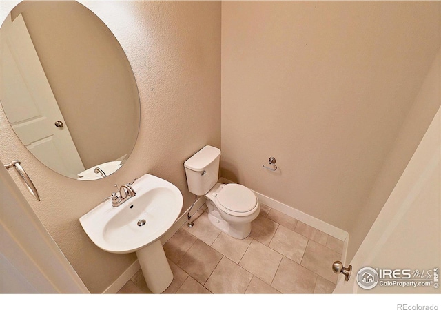 bathroom with sink, toilet, and tile patterned flooring