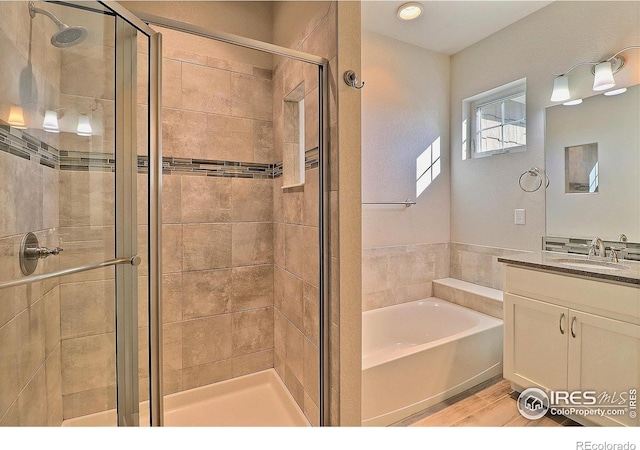 bathroom with hardwood / wood-style flooring, vanity, and separate shower and tub