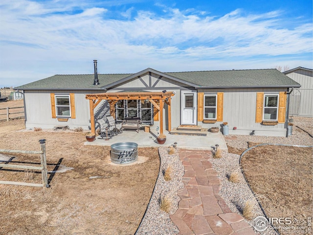 back of property with a patio and a fire pit