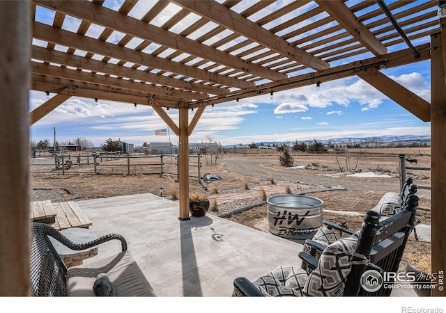 view of patio featuring a rural view and a pergola