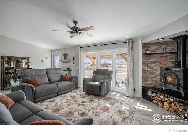 living room with lofted ceiling, ceiling fan, and light wood-type flooring