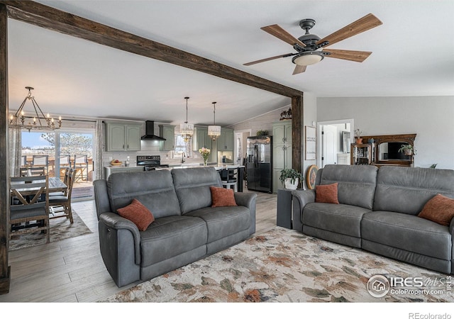 living room featuring sink, vaulted ceiling with beams, ceiling fan with notable chandelier, and light wood-type flooring