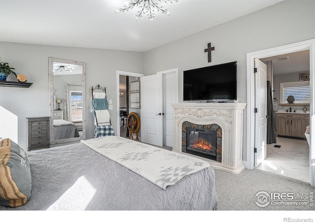 bedroom featuring ensuite bathroom and carpet