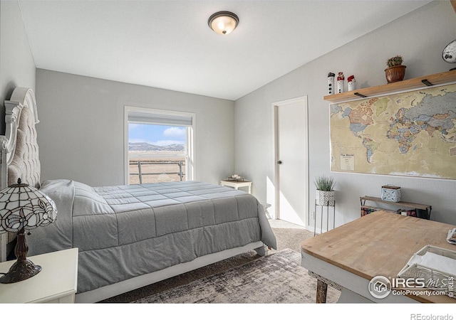 carpeted bedroom with lofted ceiling