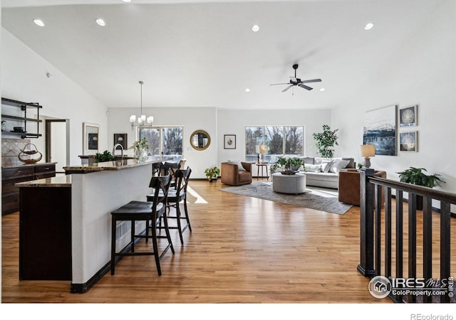 kitchen with plenty of natural light, decorative light fixtures, light hardwood / wood-style floors, and a breakfast bar area