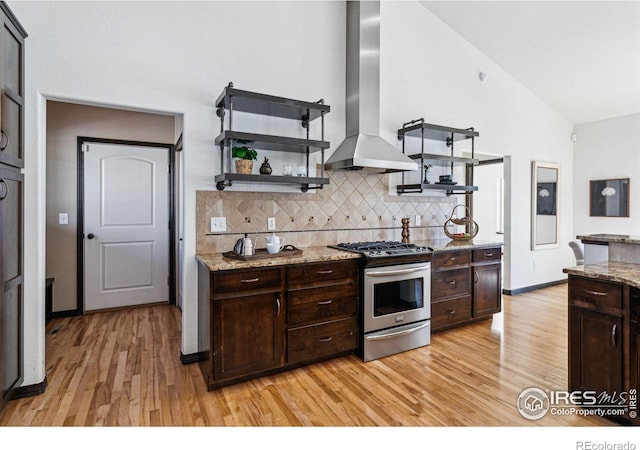 kitchen featuring dark brown cabinetry, gas range, and island range hood