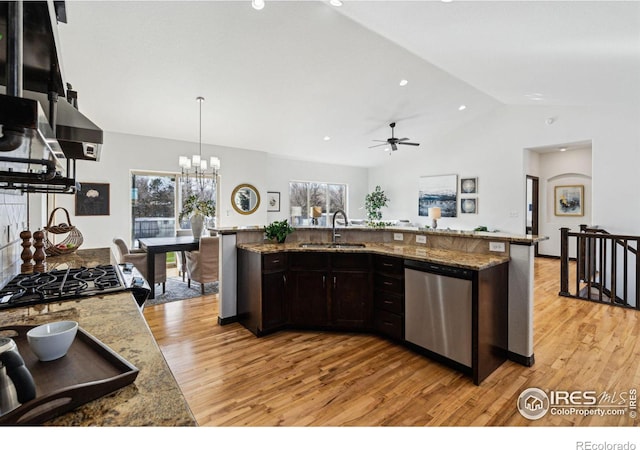 kitchen featuring pendant lighting, stainless steel dishwasher, light stone countertops, and sink