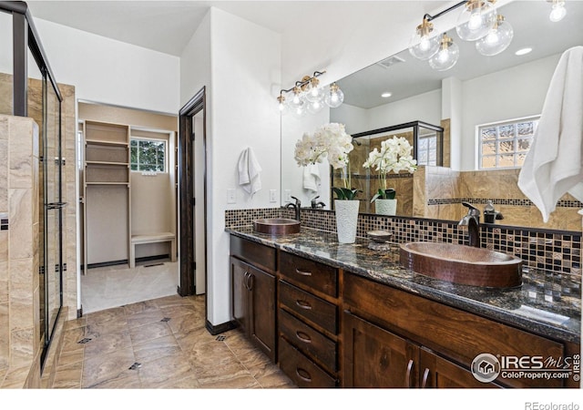 bathroom featuring vanity, backsplash, and walk in shower