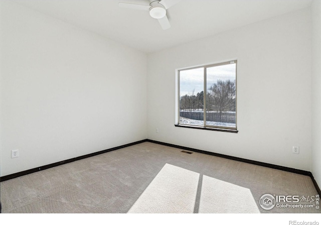 empty room with ceiling fan and light carpet