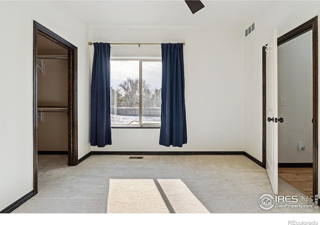 unfurnished bedroom with light colored carpet, ceiling fan, and a closet