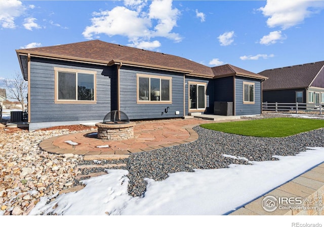 view of front of house with an outdoor fire pit, central AC unit, and a patio