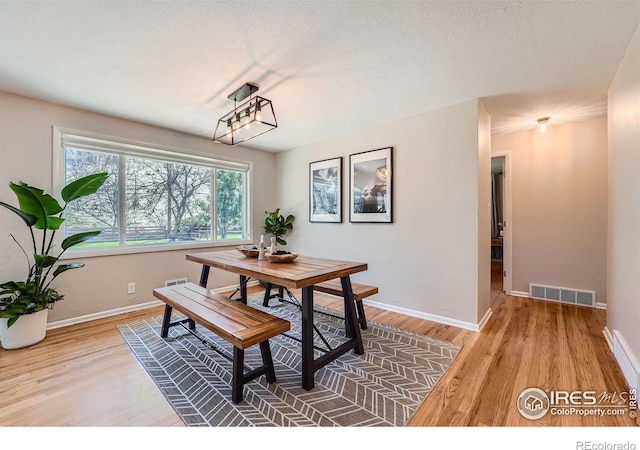 dining area featuring hardwood / wood-style flooring and a textured ceiling