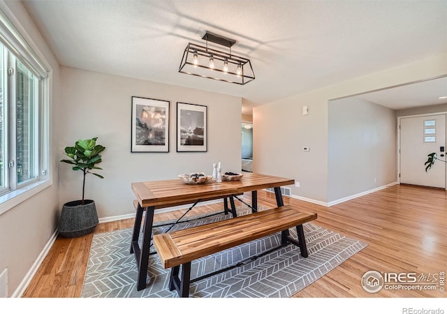 dining area featuring wood-type flooring and a textured ceiling