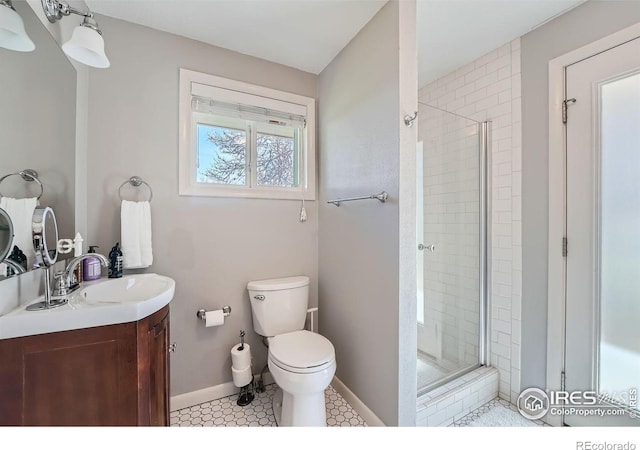 bathroom featuring vanity, toilet, and a shower with door