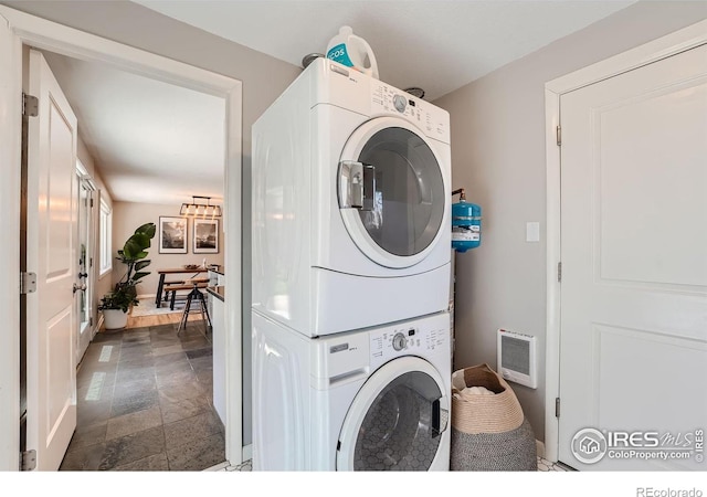 laundry area with stacked washer and dryer